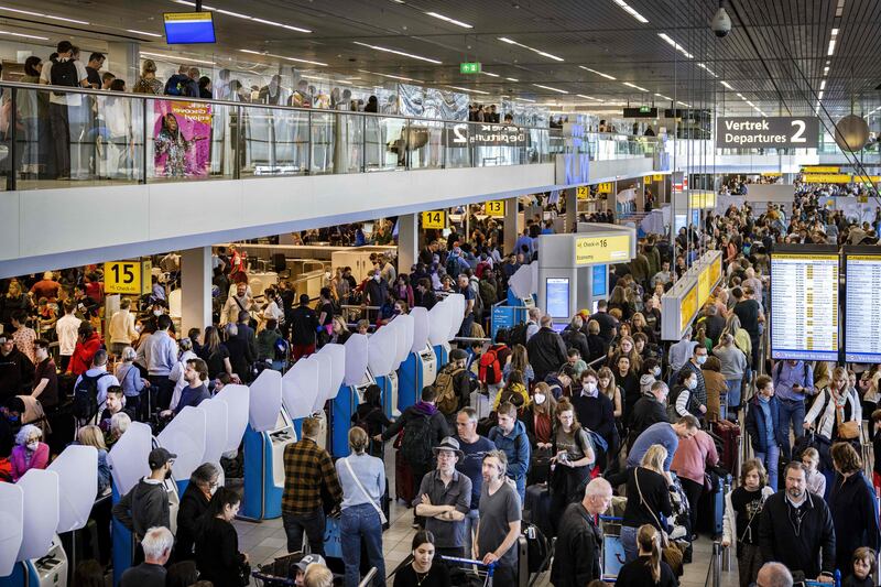 Travellers wait at the luggage claim area of Schiphol airport as KLM personnel strike. AFP