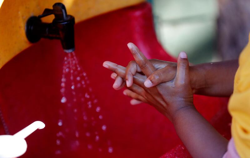 A girl washes her hands before breakfast at the Little Darling home-based Childcare after nurseries and primary schools partially reopen in England after the COVID-19 lockdown in London, Monday, June 1, 2020. (AP Photo/Frank Augstein)