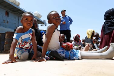 Migrants sit at a naval base after being rescued by Libyan coast guards in Tripoli last month. Almost a million people fleeing famine and warfare have made their way through hazards to reach Libya. Reuters 
