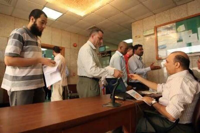 Egyptians present identification papers before voting in the presidential election run-off at the embassy in Abu Dhabi yesterday.