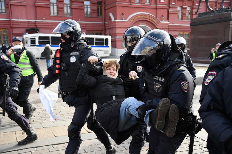 Police officers detain a woman in central Moscow, during a protest against Russian military action in Ukraine. AFP