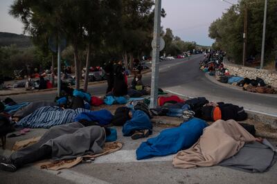 Refugees and migrants sleep on a street near the destroyed Moria camp after the fire in September 2020. AP