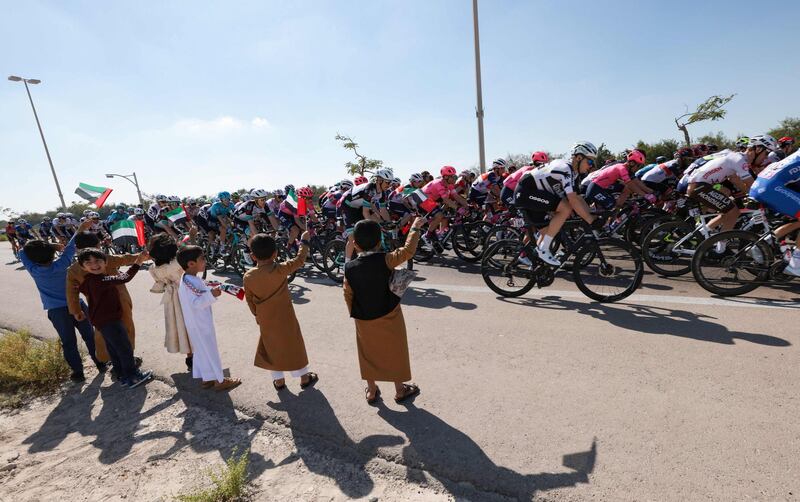 Kids wave UAE national flags during the seventh stage of the UAE Tour. AFP