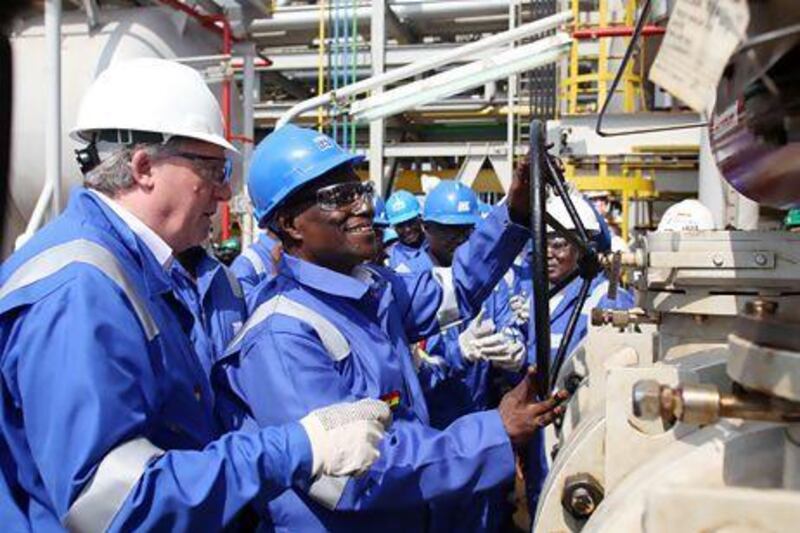 The former Ghana president John Atta Mills turns the valve to flag off first oil production at the FPSO Kwame Nkrumah oil rig. Pius Utomi Ekpei / AFP