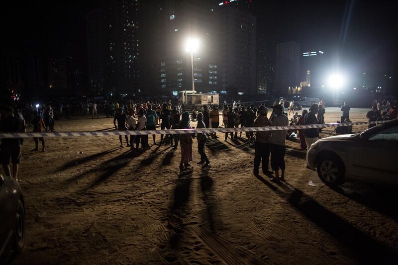 Residents of the burning high-rise building look on as fire-fighting efforts continue.  EPA