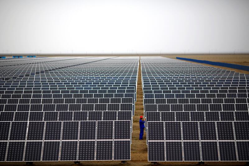 A worker inspects solar panels at a solar farm in Dunhuang, Gansu Province, China. Reuters