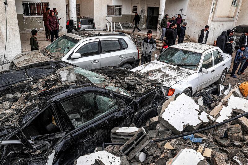 People inspect destroyed vehicles following deadly overnight Israeli bombardments of Rafah in the southern Gaza Strip. AFP