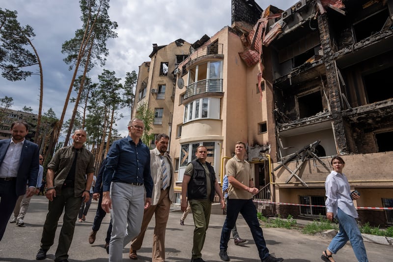 Australian Prime Minister Anthony Albanese, third left, is shown apartment buildings damaged by Russian shelling during his visit to Irpin on the outskirts of Kyiv. AP
