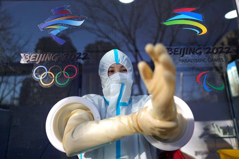 A worker prepares to administer a COVID-19 test at the 2022 Winter Olympics in Beijing. AP 