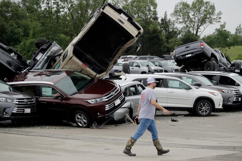 A worker walks past tornado-damaged Toyotas at a car dealership in Jefferson City. AP Photo