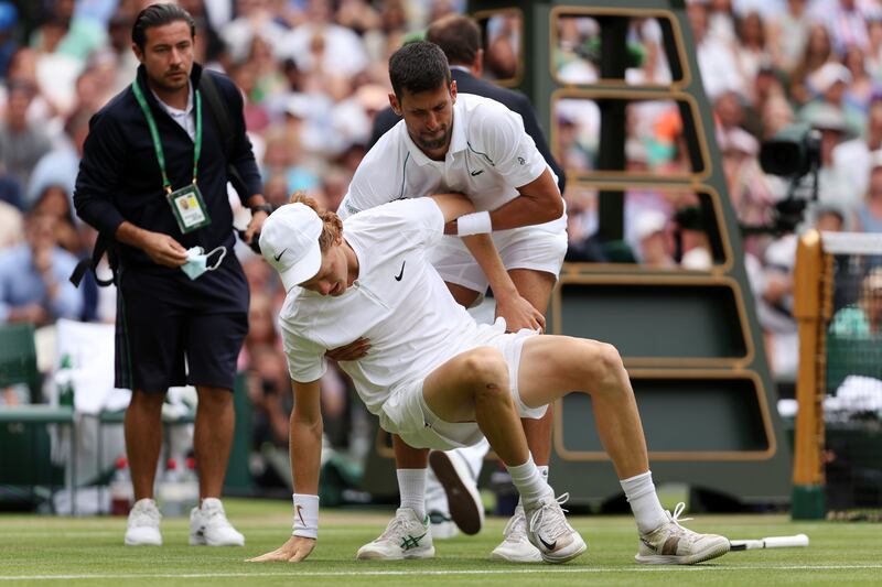  Novak Djokovic helps Jannik Sinner to his feet. Getty 