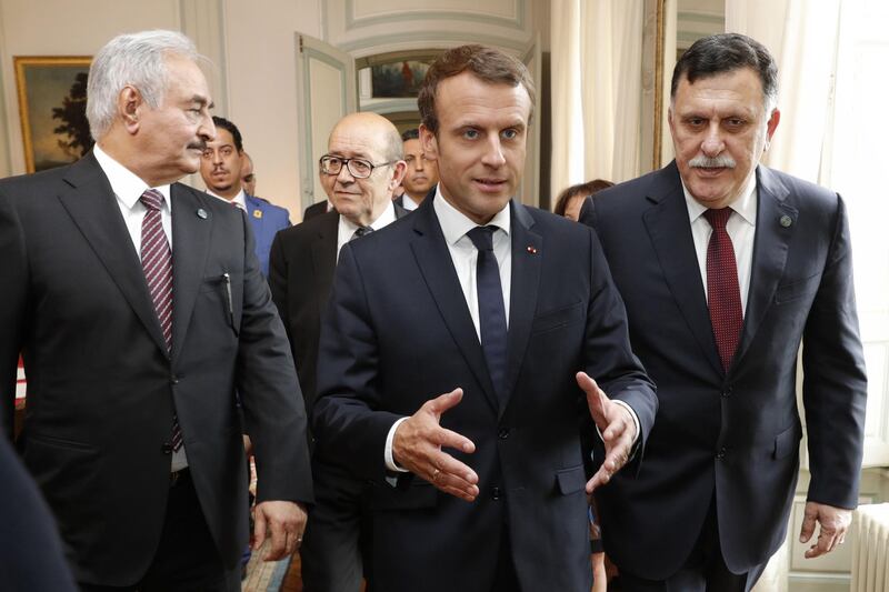French President Emmanuel Macron (C) walks with French Foreign Affairs Minister Jean-Yves Le Drian (2nd L), Libyan Prime Minister Fayez al-Sarraj (R) and General Khalifa Haftar (L), commander in the Libyan National Army (LNA), arrive for talks aimed at easing tensions in Libya, in La Celle-Saint-Cloud, near Paris, on July 25, 2017.
The two main rivals in conflict-ridden Libya are committed to a ceasefire and holding elections "as soon as possible", according to a draft statement released ahead of French-brokered talks today. The communique says Libya's UN-backed Prime Minister Fayez al-Sarraj and Khalifa Haftar, the military commander who controls the remote east of the vast country, accept that only a political solution can end the crisis.
 / AFP PHOTO / POOL / PHILIPPE WOJAZER