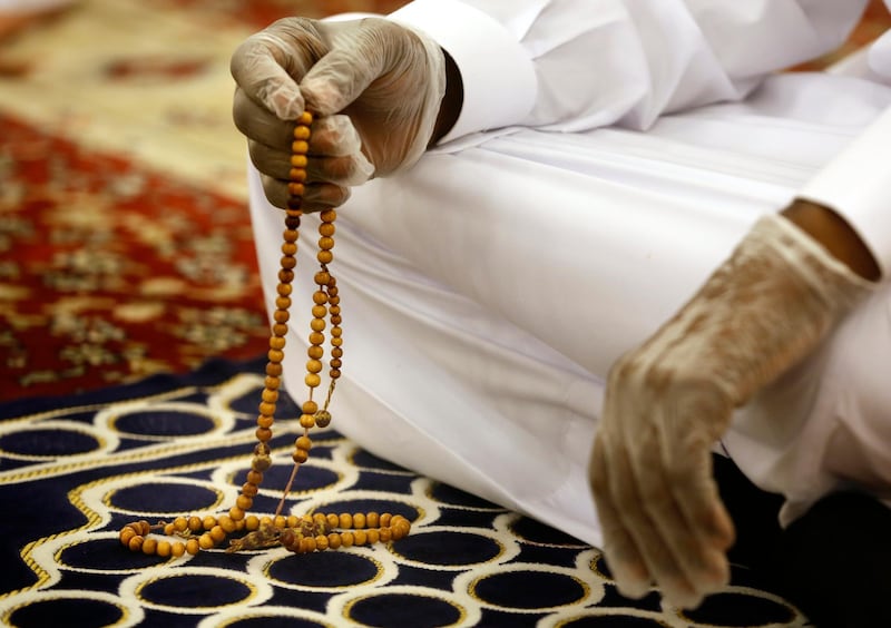 A worshipper wearing surgical gloves to prevent the spread of Covid-19 prays at Al Mirabi Mosque in Jeddah, Saudi Arabia. AP Photo