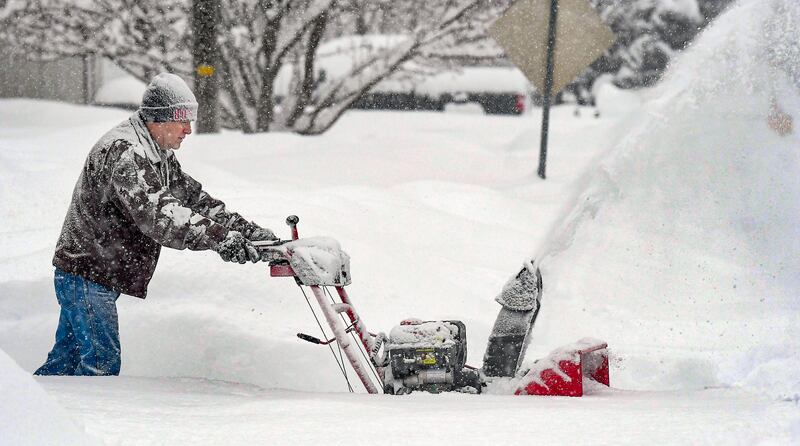 Darrell Chesley clears the snow from his driveway in Wellsville, Utah. The Herald Journal / AP