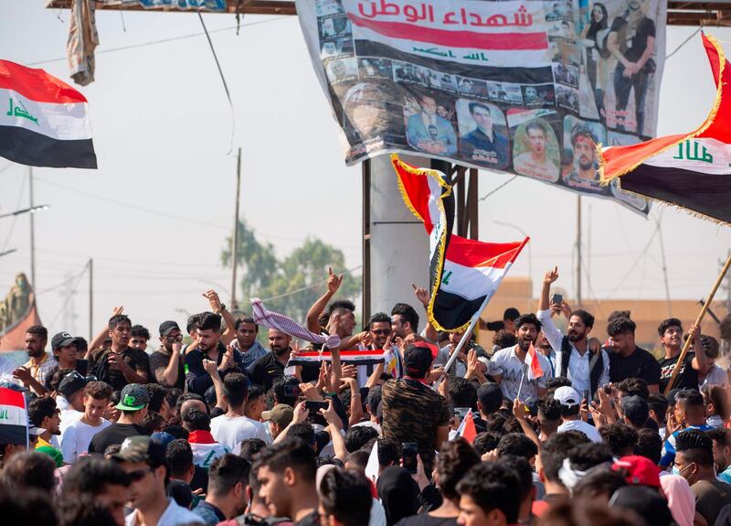 Iraqi demonstrators wave flags as they gather near the local administration building in the southern city of Basra. AFP