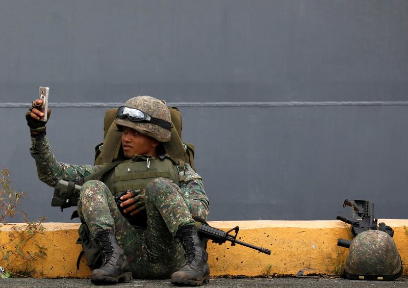 A Philippine marine soldier takes a selfie with his phone during their arrival from Marawi at port area in metro Manila, Philippines. Dondi Tawatao / Reuters