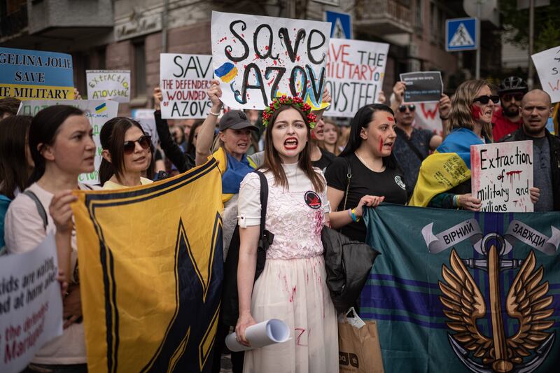 People hold banners and shout slogans during a demonstration in support of Mariupol defenders in Kyiv, Ukraine. Getty Images