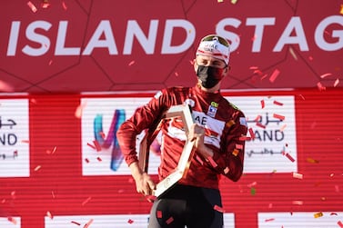Tadej Pogacar of Team UAE Emirates celebrates on the podium after winning the UAE Cycling Tour from Yas Mall to Abu Dhabi Breakwater, on February 27, 2021. / AFP / Giuseppe CACACE