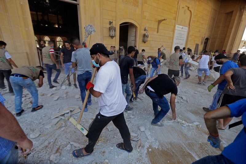People clean debris at Mohammed al-Amin mosque in the centre of Beirut on August 5, 2020 in the aftermath of a massive explosion in the Lebanese capital. Rescuers searched for survivors in Beirut after a cataclysmic explosion at the port sowed devastation across entire neighbourhoods, killing more than 100 people, wounding thousands and plunging Lebanon deeper into crisis. The blast, which appeared to have been caused by a fire igniting 2,750 tonnes of ammonium nitrate left unsecured in a warehouse, was felt as far away as Cyprus, some 150 miles (240 kilometres) to the northwest.
 / AFP / JOSEPH EID
