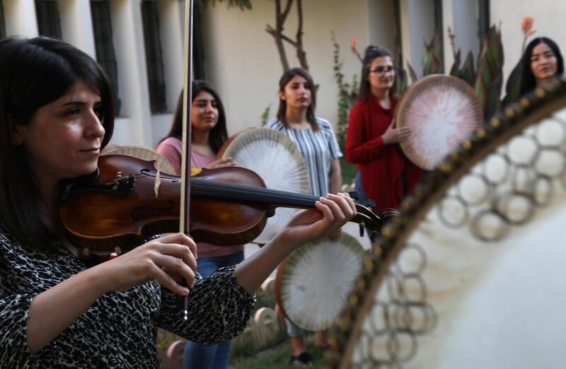 Young Yazidi and Muslim women, part of the musical group "40 Plaits," rehearse a traditional Kurdish song accompanied by the Daf, a large Kurdish frame drum, in a community centre in Dahuk.  AFP