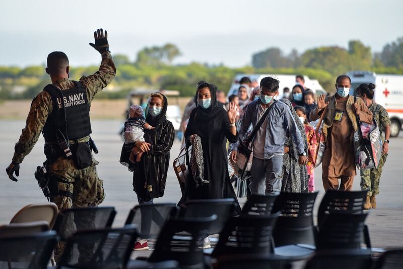 Refugees receive instructions from a US navy soldier as they disembark from a US air force aircraft after an evacuation flight from Kabul at the Rota naval base in southern Spain on Tuesday. AFP