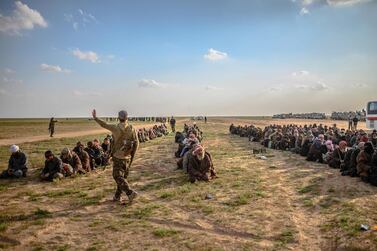 Men suspected of being ISIS fighters wait to be searched by members of the Kurdish-led Syrian Democratic Forces (SDF) in Syria's northern Deir Ezzor province on February 22, 2019. AFP