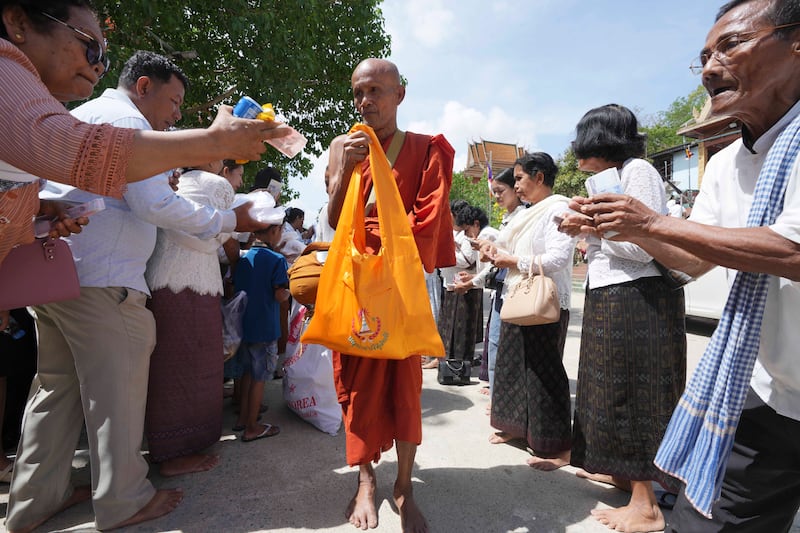 A Buddhist monk receives alms from devotees during the Buddhist Visak Bochea festival at Praseth Leu pagoda, north-west of Phnom Penh, Cambodia. AP