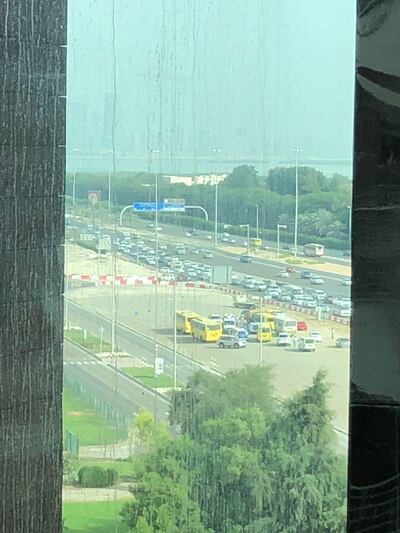 The four school buses involved in the accident are parked on a sand lot near TwoFour54 as police investigate the crash on Thursday morning. The National