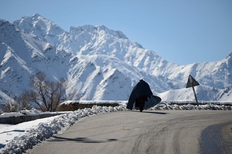 An Afghan woman walks along a road in Panjshir Province, north of the capital Kabul. AFP