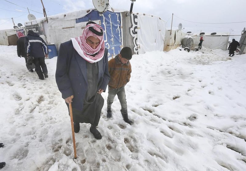 An old Syrian man helped by his grandson walks on the snow at their refugee camp in Al Faour village in Lebanon's Bekaa Valley on January 8. AP Photo