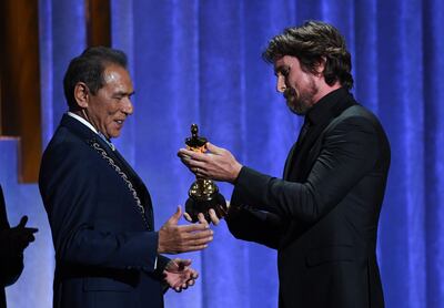 British actor Christian Bale (R) presents actor Wes Studi (L) with his honorary award onstage at the 11th Annual Governors Awards gala hosted by the Academy of Motion Picture Arts and Sciences at the Dolby Theater in Hollywood on October 27, 2019.  / AFP / Valerie MACON
