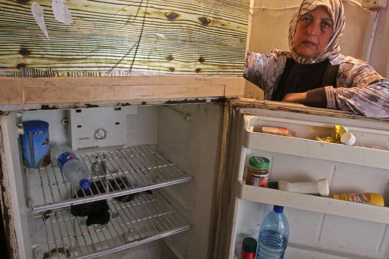 A Lebanese woman displays the content of her refrigerator at her apartment in the southern city of Sidon. AFP