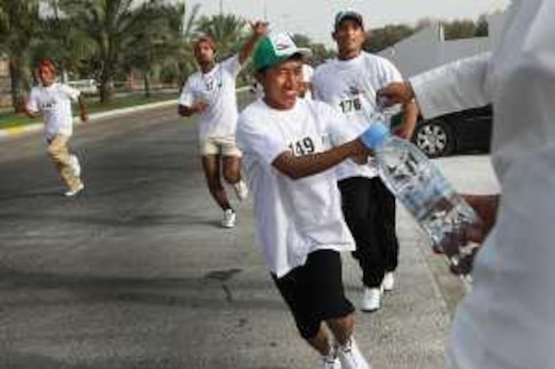 Abu Dhabi, United Arab Emirates - May 1, 2009  Racers grab water during a race marathon for laborours held by the Department of Labor. ( Delores Johnson / The National )
