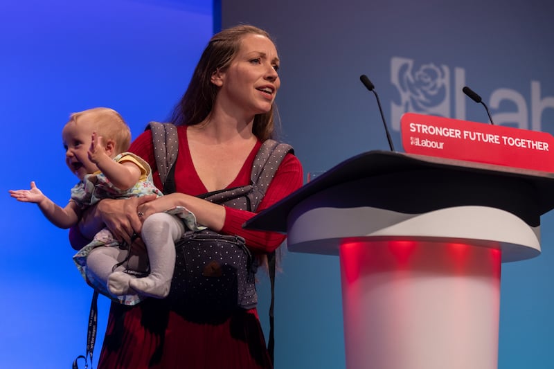 Catherine Atkinson, whose husband served in Afghanistan, holds nine-month-old Elena as she addresses delegates. Getty Images
