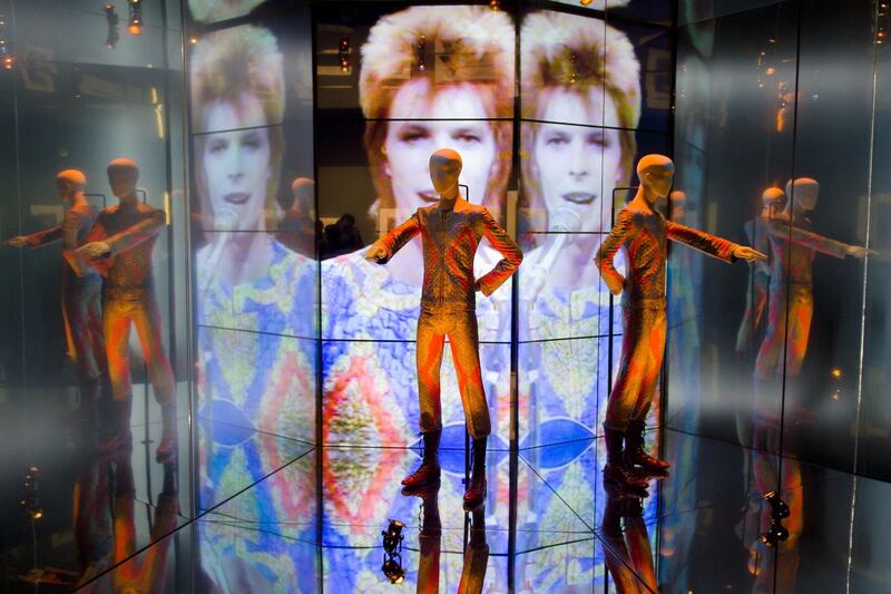 The "Starman" costume from David Bowie's appearance on "Top of the Pops" in 1972 is displayed at the "David Bowie is" exhibition at the Victoria and Albert (V&A) museum in central London on March 20, 2013. Running March 23 to August 11, the exhibition features more than 300 objects that include handwritten lyrics, original costumes, fashion, photography, film, music videos, set designs and Bowie's own instruments.  AFP PHOTO/Leon Neal (Photo by LEON NEAL / AFP)