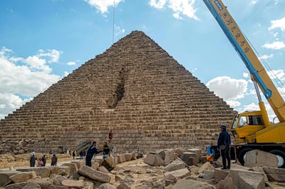 Workers lift blocks using a crane as part of the disputed restoration project, at the base of the Pyramid of Menkaure, at Giza. AFP