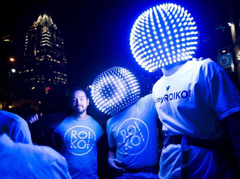 Representatives from the internet social media service ROI KOI wear light-up globes on Sixth Street during the music portion of South by Southwest in Austin, Texas. South by Southwest Conferences and Festivals offer the unique convergence of original music, independent films and emerging technologies. Ashley Landis / EPA