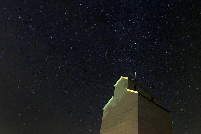 In this photo taken with long exposure, a meteor streaks across the sky behind a grain elevator in Baxter, Iowa. Charlie Riedel / AP Photo