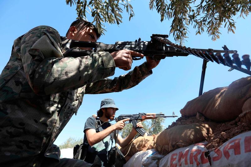 Rebel fighters from the Suqur Al-Sham brigades take a position in the countryside of the northern Idlib province, Syria. AFP