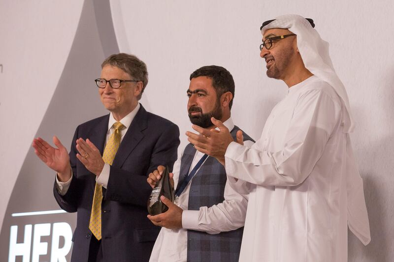 ABU DHABI, UNITED ARAB EMIRATES - December 6, 2015: HH Sheikh Mohamed bin Zayed Al Nahyan, Crown Prince of Abu Dhabi and Deputy Supreme Commander of the UAE Armed Forces (R), and Bill Gates, Co-chair, Bill & Melinda Gates Foundation (L), present the Heroes of Polio Eradication (HOPE) Education award to Atta Ullah, Chairman of a local support organization in Khyber Pakhtunkwa, Pakistan (C), during the HOPE awards ceremony at Al Mamoura. 
( Mohamed Al Hammadi / Crown Prince Court - Abu Dhabi ) *** Local Caption ***  20151206MH_C099701.JPG