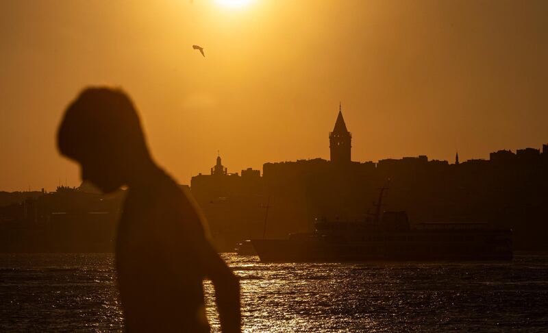 epa08620361 A child walks near the Bosphorus backdropped by the Galata Tower at sunset  in Istanbul, Turkey, 23 August 2020. Turkish authorities have now allowed the reopening of restaurants, cafes, parks and beaches, as well as lifting the ban on inter-city travel, as the country eases the restrictions it had imposed in a bid to stem the spread of the ongoing pandemic of the COVID-19 disease caused by the SARS-CoV-2 coronavirus.  EPA/ERDEM SAHIN