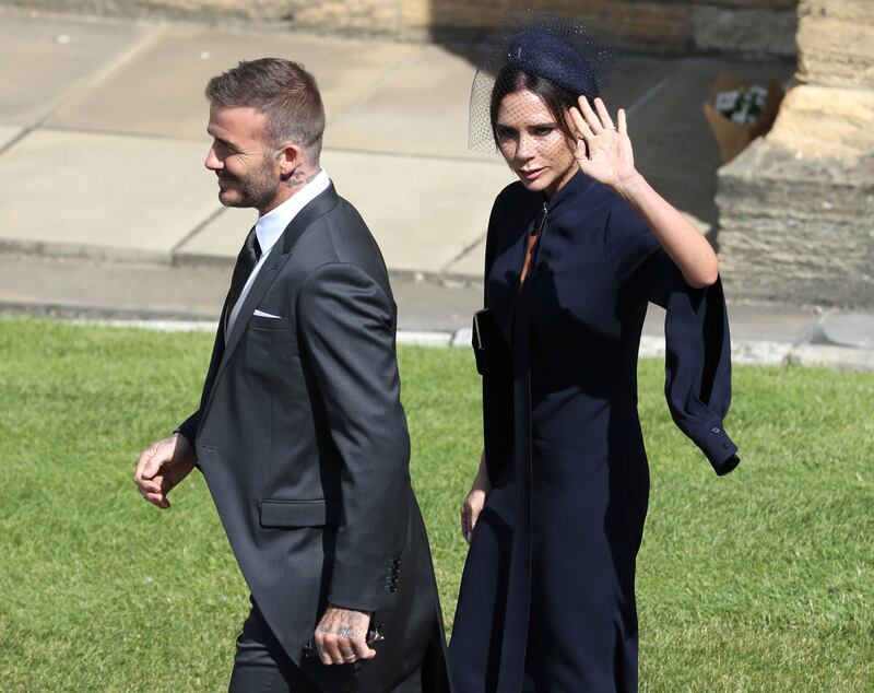Former England footballer David Beckham (L) and fashion designer Victoria Beckham (R) arrive for the wedding ceremony of Britain's Prince Harry, Duke of Sussex and US actress Meghan Markle at St George's Chapel, Windsor Castle, in Windsor, on May 19, 2018. / AFP PHOTO / POOL / Andrew Milligan