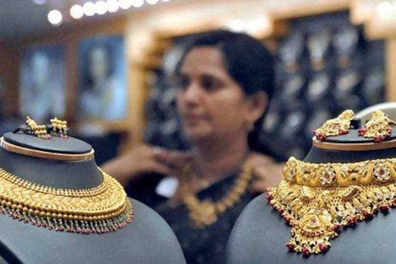 A woman tries on a gold necklace in a Hyderabad jewellery shop. Holding assets in gold is a useful hedge against extreme events. Krishnendu Halder / Reuters