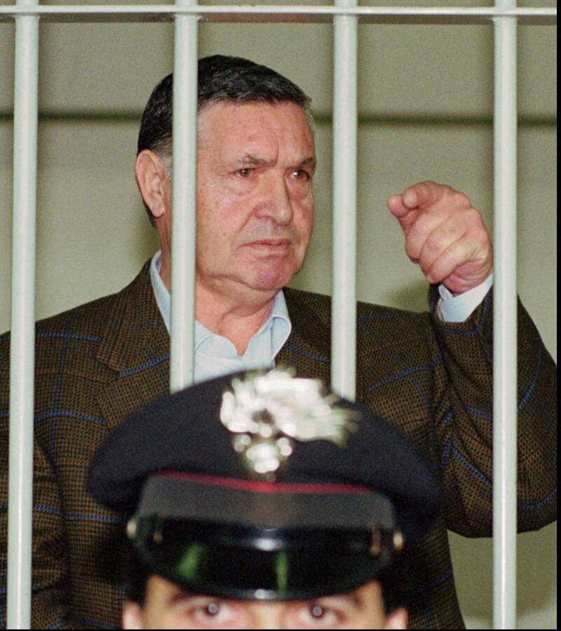 FILE - In this April 29, 1993 file photo, Mafia "boss of bosses" Salvatore "Toto" Riina, is seen behind bars, during a trial in Rome. Italyâ€™s justice minister has given special permission for family bedside visits to the comatose top Mafia boss. Italian media said Riinaâ€™s health deteriorated recently after undergoing two recent surgeries. (AP Photo/Giulio Broglio)