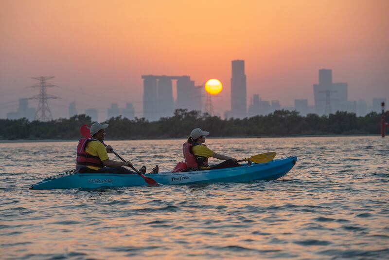 Visitors enjoy an evening paddle by the mangroves and a sunset view of Abu Dhabi.