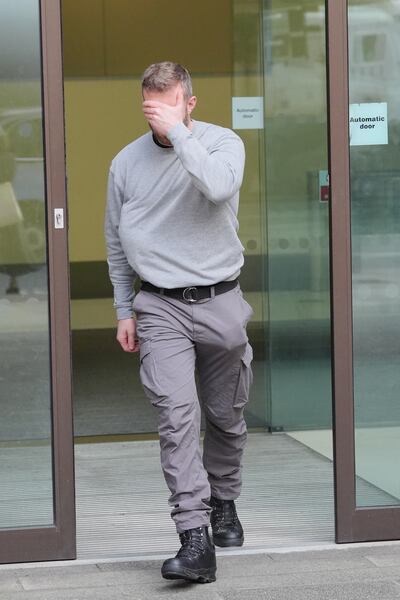 Matthew Trickett covers his face as he leaves Westminster Magistrates' Court after appearing in court accused of assisting the Hong Kong intelligence service. PA 