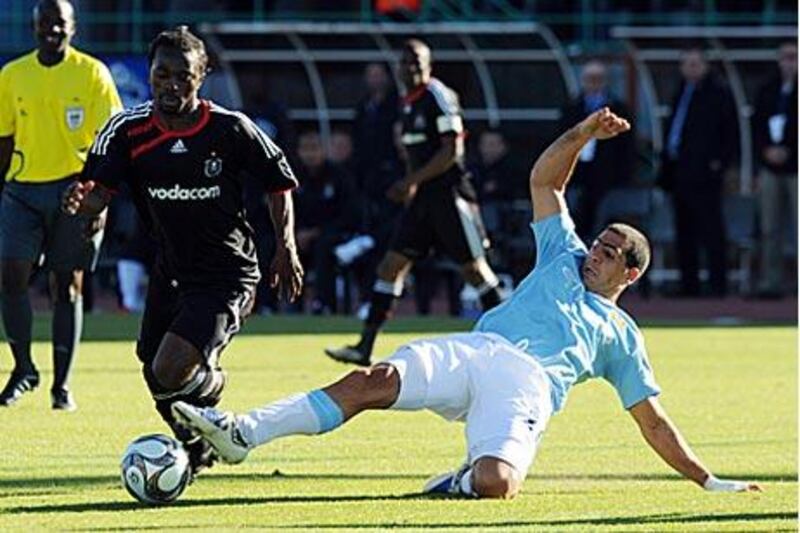 Manchester City's Tal Ben Haim, right, tries to tackle Orlando Pirates' Siphelele Mtllembu.