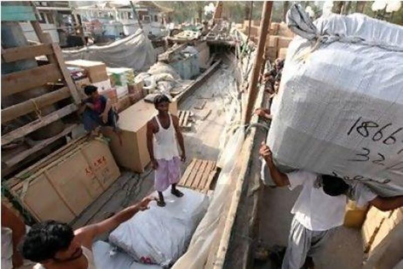 Workers loading goods on to dhows last year in Dubai Creek to be shipped to Iran. Paulo Vecina / The National