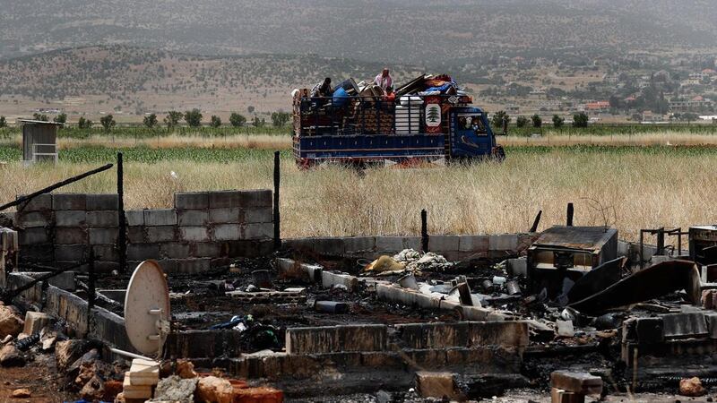 A Syrian family leaves with their belongings from an informal refugee camp in Deir Al Ahmar, east Lebanon. AP