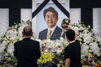 People leave flowers and pay their respects to former Japanese prime minister Shinzo Abe outside the Nippon Budokan in Tokyo on Friday. AFP